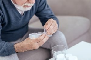 Senior managing his medications in home